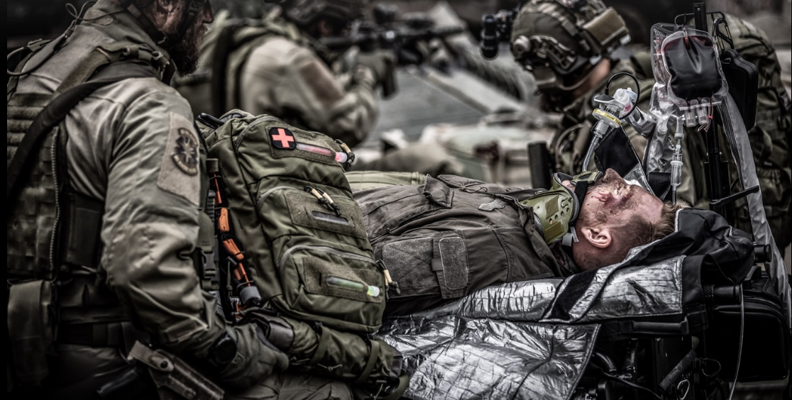 Tactical medic with Medic 18 pack in combat casualty scenario