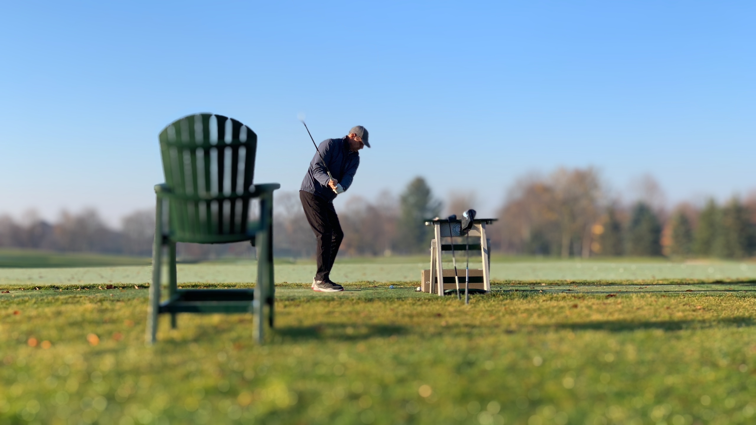 Golfer swinging on the course in fall conditions