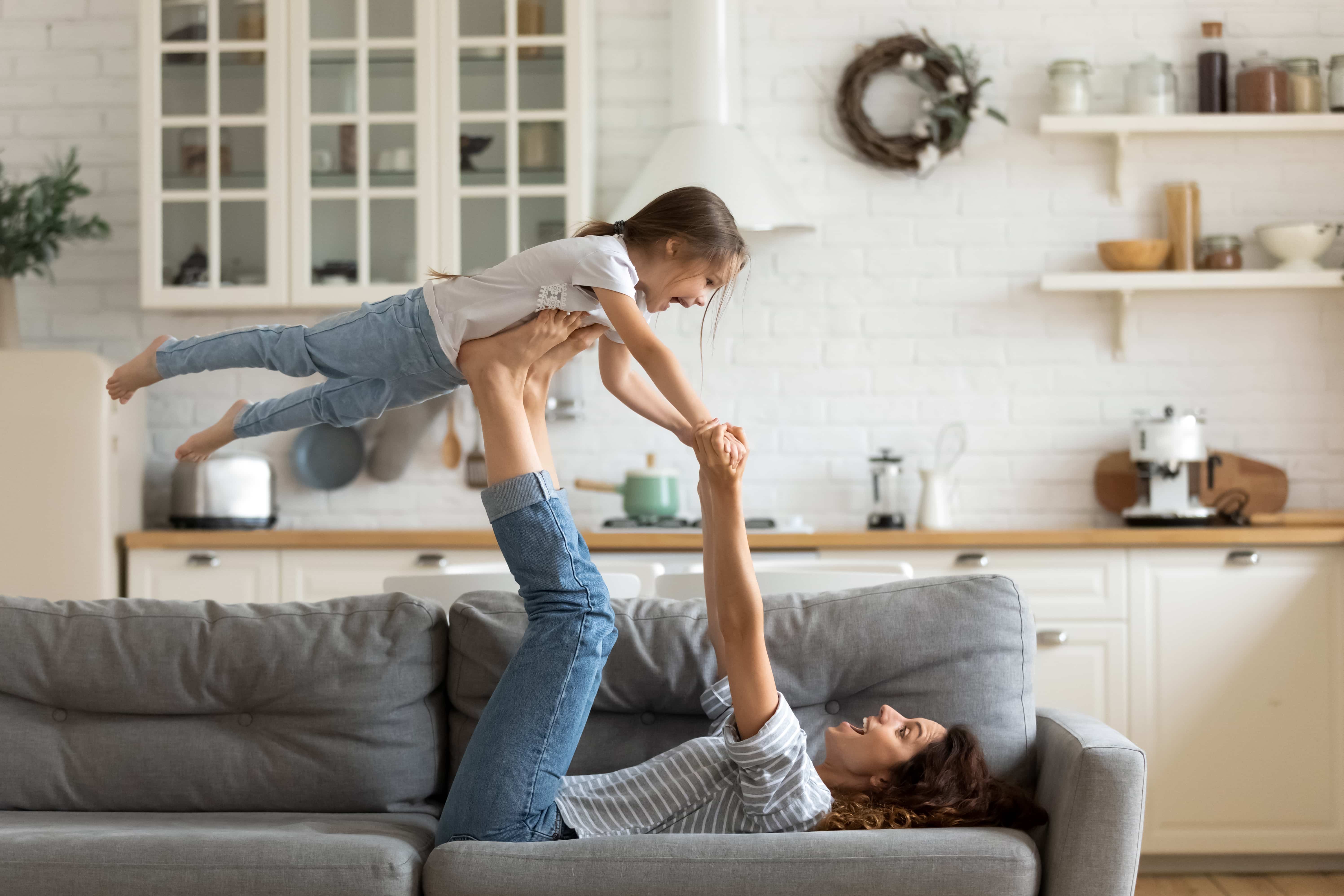Mother and child playing together on a comfortable sofa, enjoying quality family time in their Louisville home
